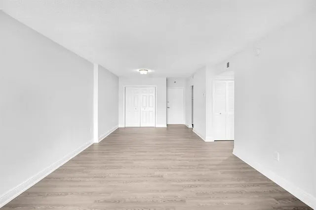 a view of an empty room with wooden floor