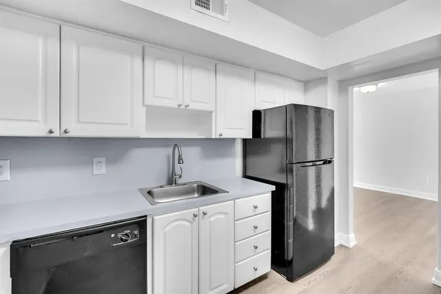 a kitchen with appliances a refrigerator and cabinets