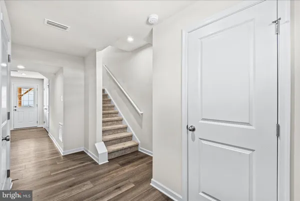 a view of a hallway with wooden floor and entryway