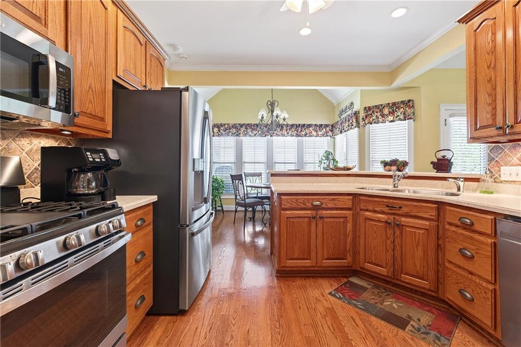 865 Laurel Ridge Road Cleveland, GA 30528 - Photo 21 of 81 a kitchen with stainless steel appliances a stove a sink dishwasher a microwave oven and a dining table with wooden floor