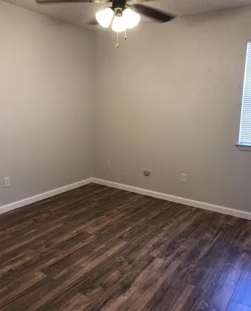 a view of a room with wooden floor and white walls