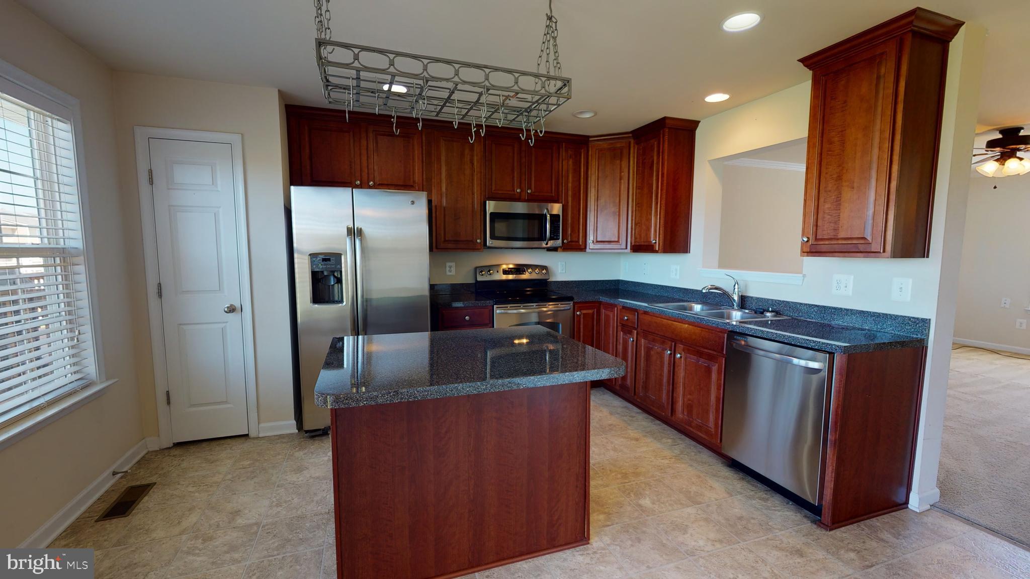 1141 Mare Street Ranson, WV 25438 - Photo 8 of 21 a kitchen with stainless steel appliances granite countertop a sink stove and refrigerator