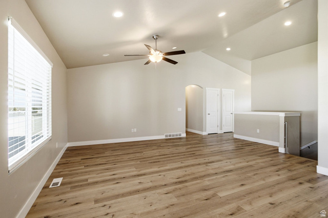 664 South Saddle Road Grantsville, UT 84029 - Photo 9 of 39 Vaulted ceiling with recessed lighting, wood-finish flooring, ceiling fan with light fixture, large window with blinds, and an arched doorway