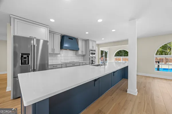 a spacious bathroom with a granite countertop tub a double vanity sink a mirror and a window