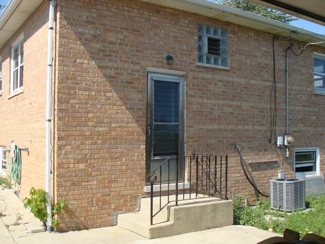 10819 Menard Avenue Chicago Ridge, IL 60415 - Photo 3 of 8 a brick building with a bench and a porch