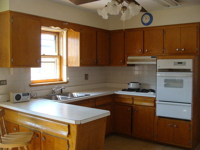 10819 Menard Avenue Chicago Ridge, IL 60415 - Photo 4 of 8 a kitchen with a sink a stove cabinets and a window