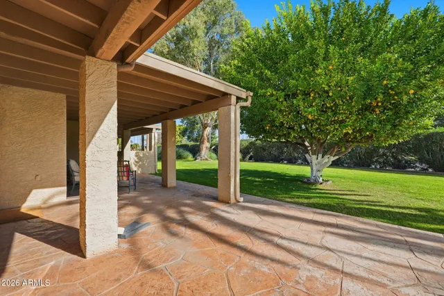 a view of a patio with a table chairs and a backyard