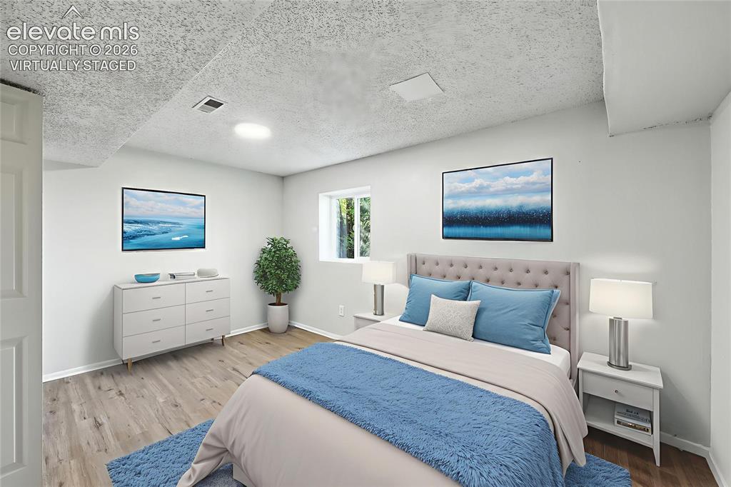 7033 Sequoyah Way Colorado Springs, CO 80915 - Photo 11 of 20 a spacious bedroom with a bed and a flat screen tv