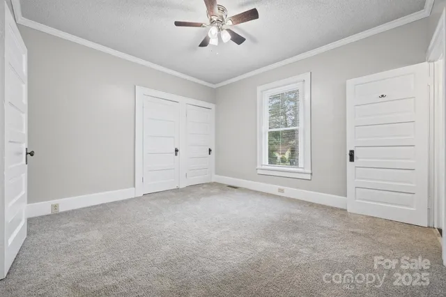 an empty room with closet and windows