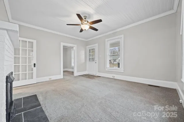 a view of a livingroom with a fireplace and window