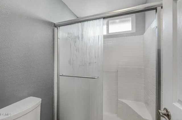 a bedroom with a bed a flat screen tv and a window