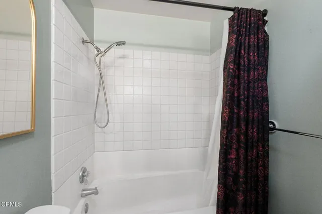 a bedroom with bed and a painting on the wall