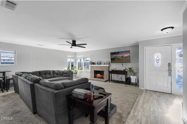 a living room with furniture and a ceiling fan