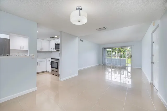 a view of a kitchen with wooden floor and a window
