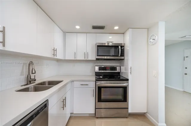 a kitchen with sink a microwave and cabinets
