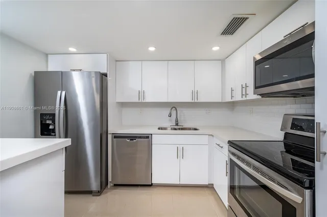 a kitchen with stainless steel appliances granite countertop a stove a refrigerator and a microwave