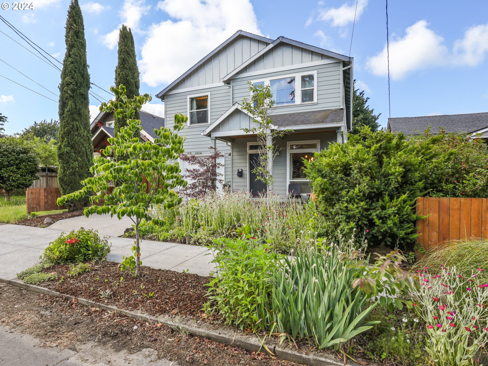 6924 Southeast Boise Street Portland, OR 97206 - Photo 12 of 45 a front view of a house with a yard and potted plants