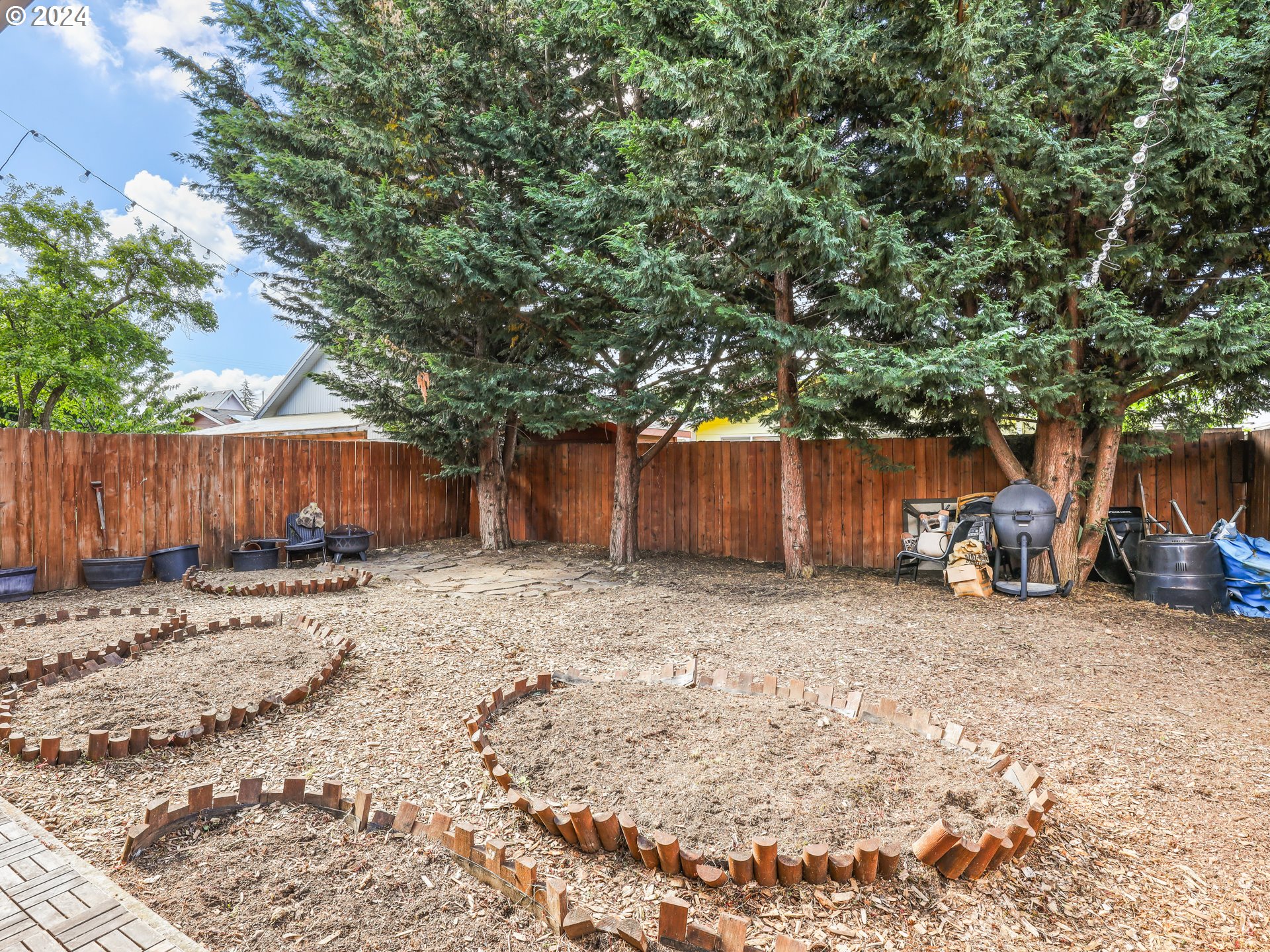 6924 Southeast Boise Street Portland, OR 97206 - Photo 37 of 45 a view of a backyard with large tree and wooden fence