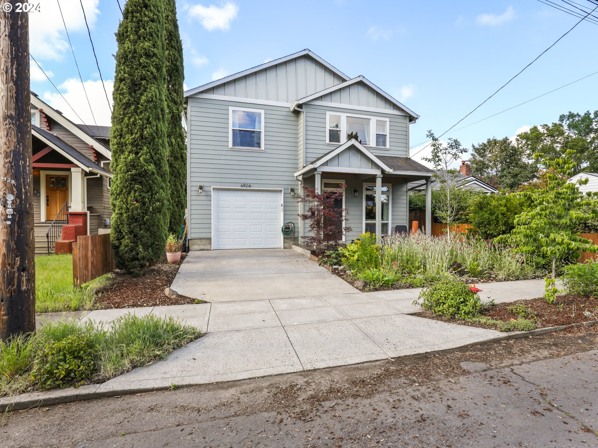 6924 Southeast Boise Street Portland, OR 97206 - Photo 41 of 45 a front view of a house with a yard and garage