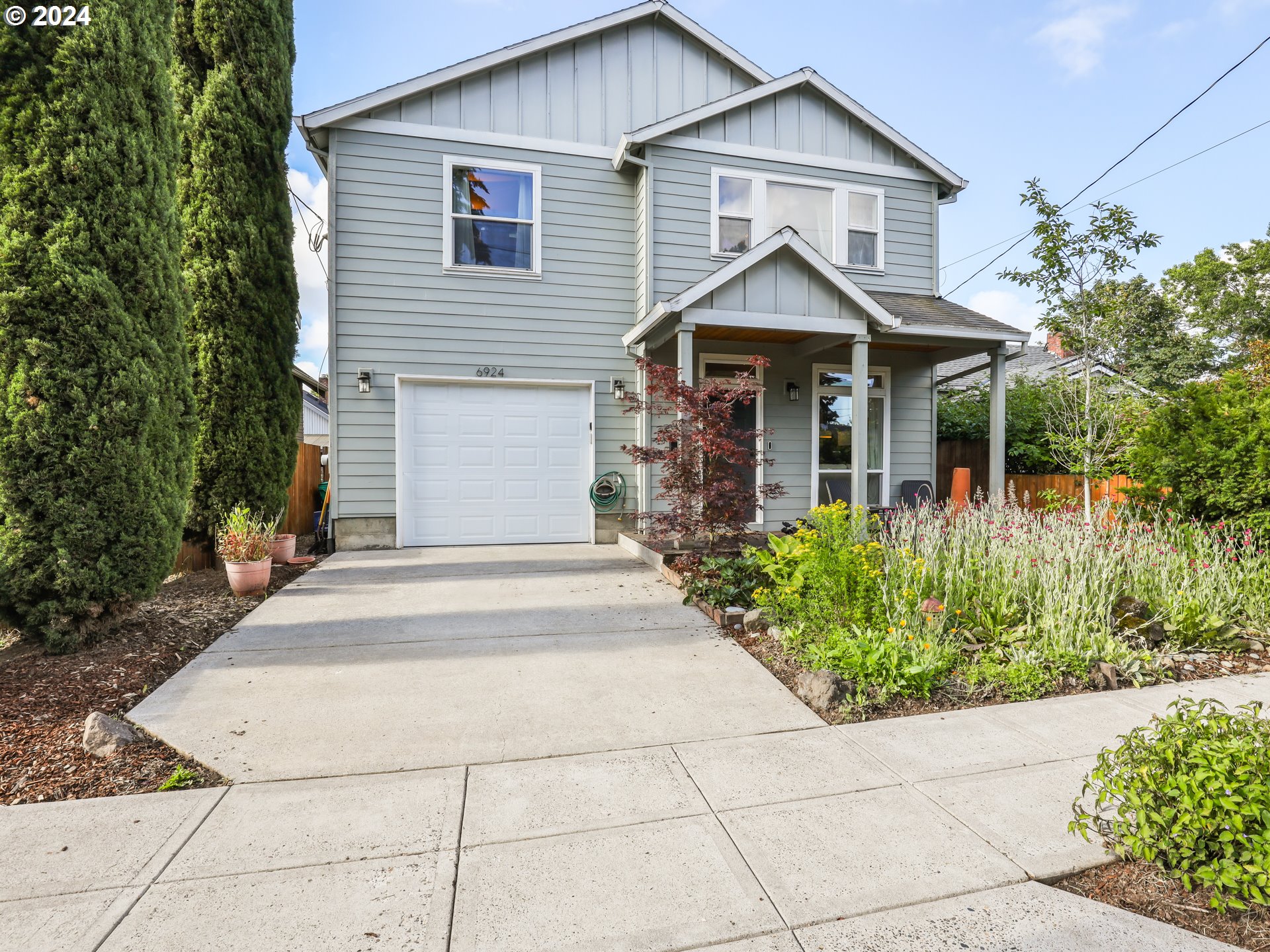 6924 Southeast Boise Street Portland, OR 97206 - Photo 42 of 45 a front view of a house with a yard and trees
