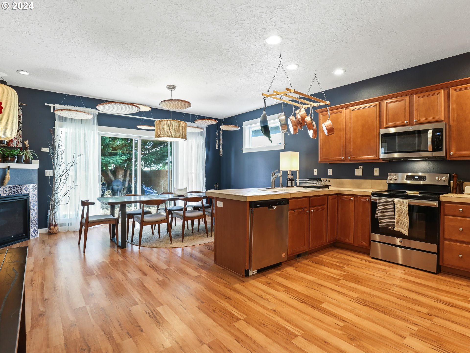 6924 Southeast Boise Street Portland, OR 97206 - Photo 7 of 45 a kitchen with stainless steel appliances wooden floors stove and wooden cabinets