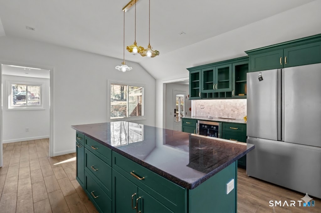 343 Hope Furnace Road Hope, RI 02831 - Photo 31 of 35 a kitchen with stainless steel appliances granite countertop a refrigerator a sink dishwasher and wooden cabinets with wooden floor