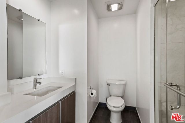 a bathroom with a granite countertop sink a toilet and a mirror