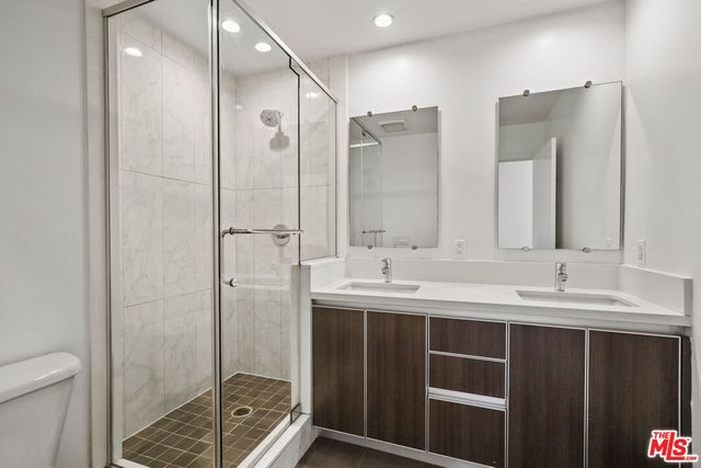 a bathroom with a double vanity sink mirror and shower