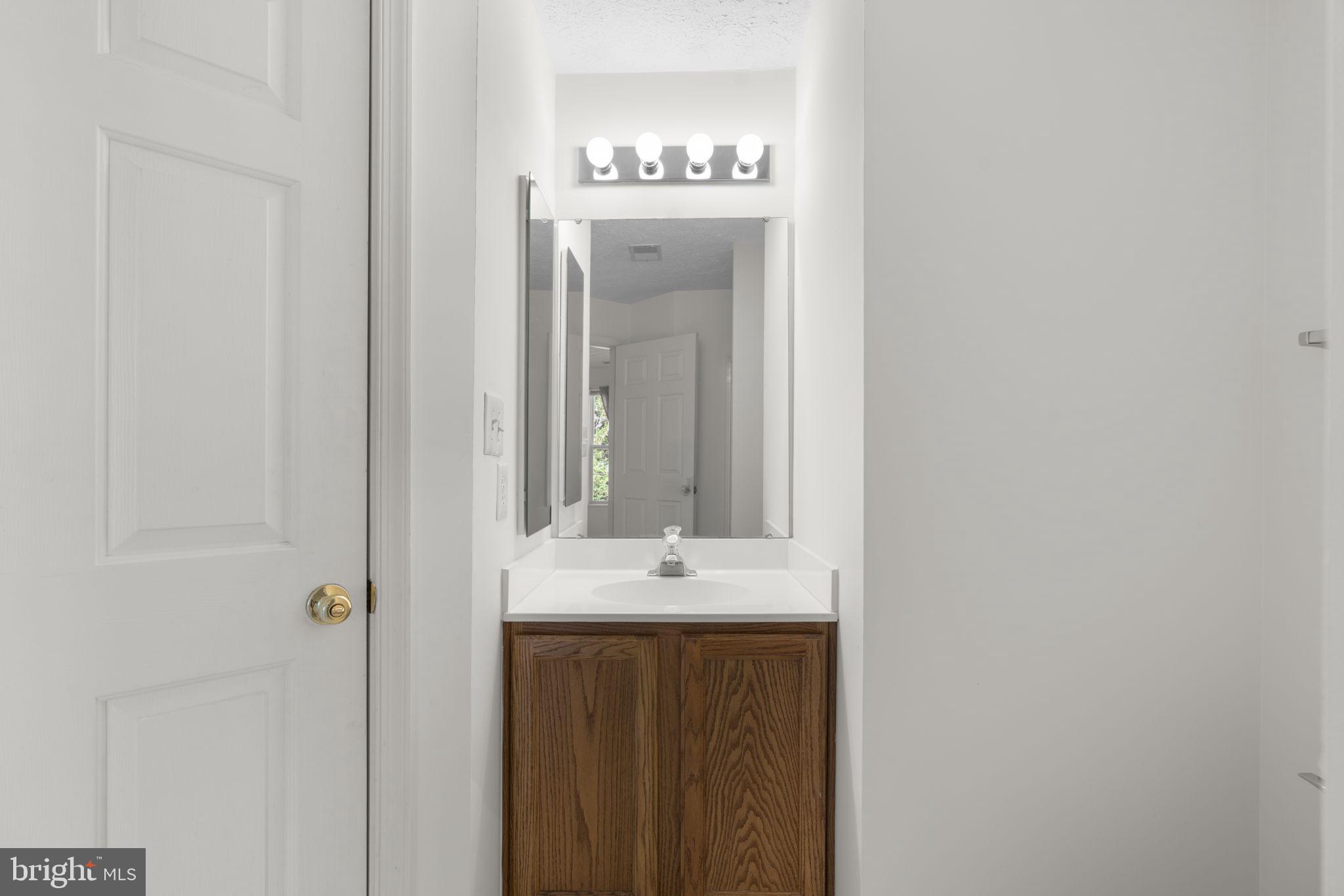 2444 Blue Spring Court, Unit 203 Odenton, MD 21113 - Photo 26 of 36 a bathroom with a sink and a mirror
