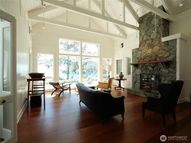 a living room with fireplace furniture and a large window