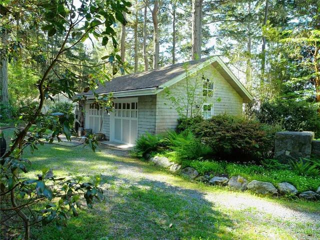 a backyard of a house with plants and large trees