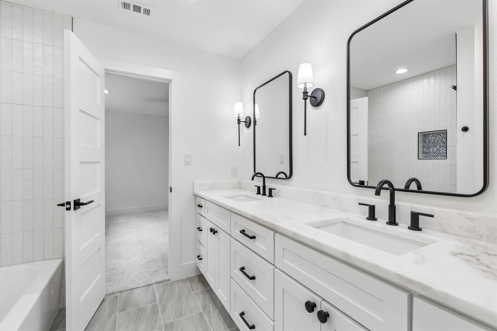 7124 Meadow Road Dallas, TX 75230 - Photo 26 of 36 Jack and jill bathroom includes bathrub,dual sinks,and plenty of storage
