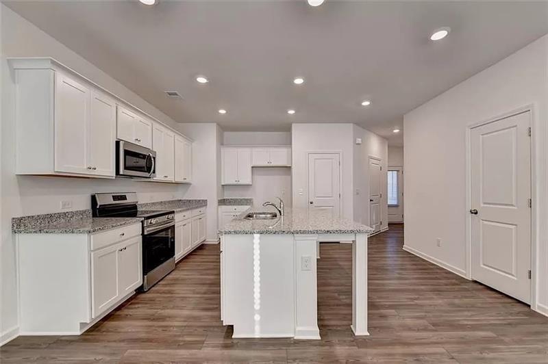 100 Mission Boulevard Pendergrass, GA 30567 - Photo 6 of 17 a large kitchen with stainless steel appliances granite countertop a stove a sink and a refrigerator