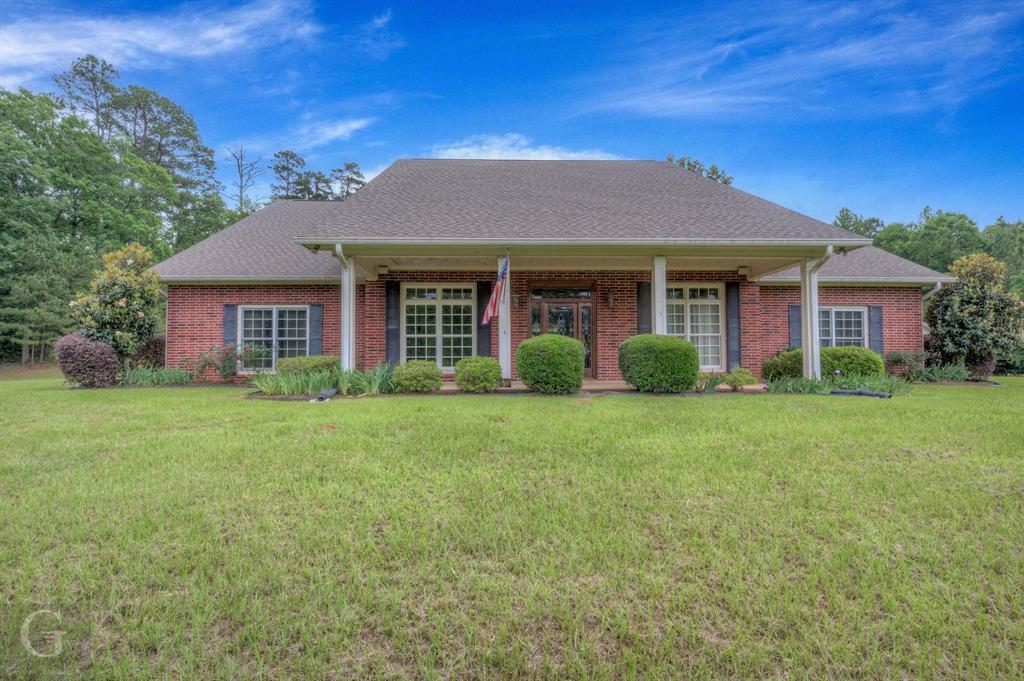 1212 WPA Road Homer, LA 71040 - Photo 1 of 35 View of front of home featuring a front lawn, brick siding, a shingled roof, and covered porch