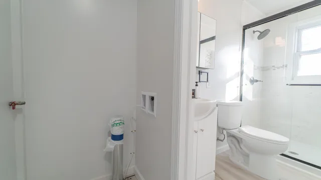 a white toilet sitting next to a bathroom sink and vanity