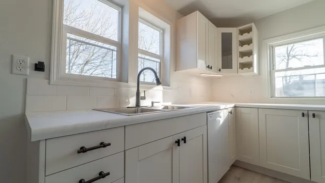 a kitchen with a sink window and cabinets
