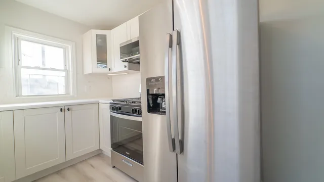a kitchen with stainless steel appliances granite countertop a refrigerator and a stove