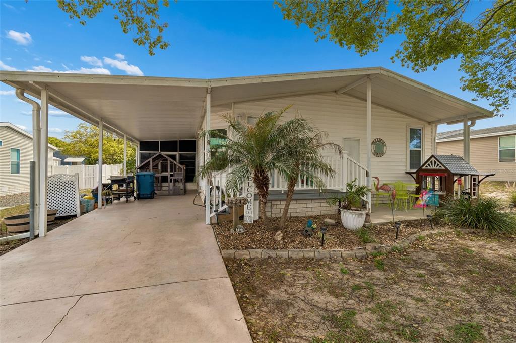 a backyard of a house with table and chairs under an umbrella