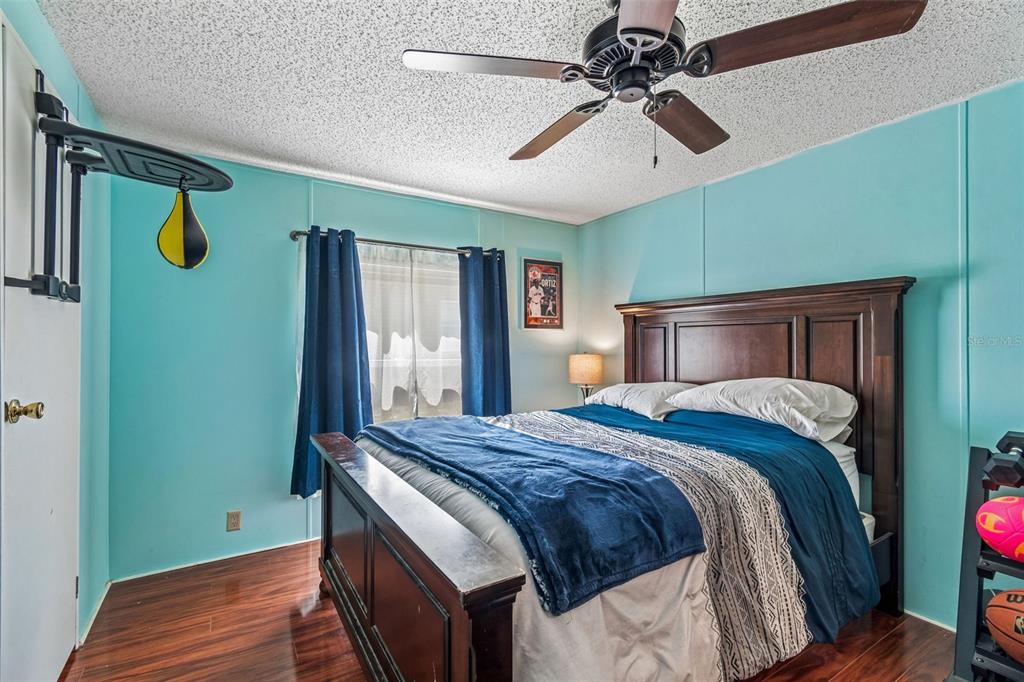 14242 Action Street Brooksville, FL 34613 - Photo 22 of 60 a bedroom with a bed and a chandelier