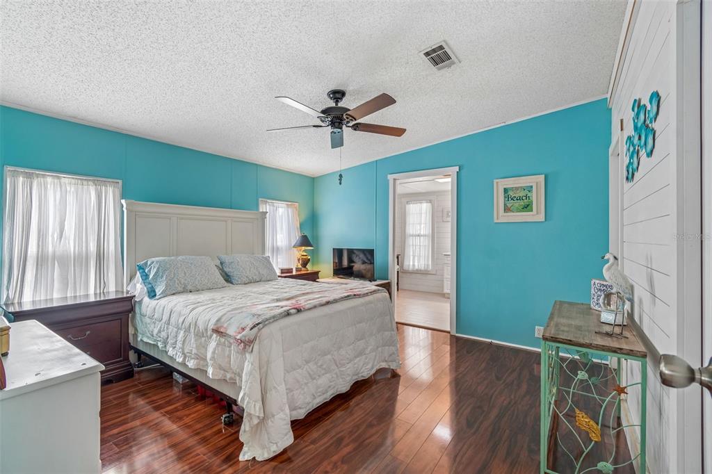 14242 Action Street Brooksville, FL 34613 - Photo 25 of 60 a bedroom with a bed and a chandelier