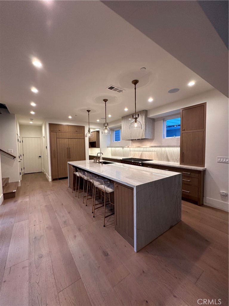 a kitchen with stainless steel appliances granite countertop a lot of cabinets and wooden floor