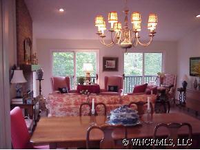 39 Hunting Country Road Tryon, NC 28782 - Photo 5 of 8 a view of a dining room with furniture a chandelier and large windows