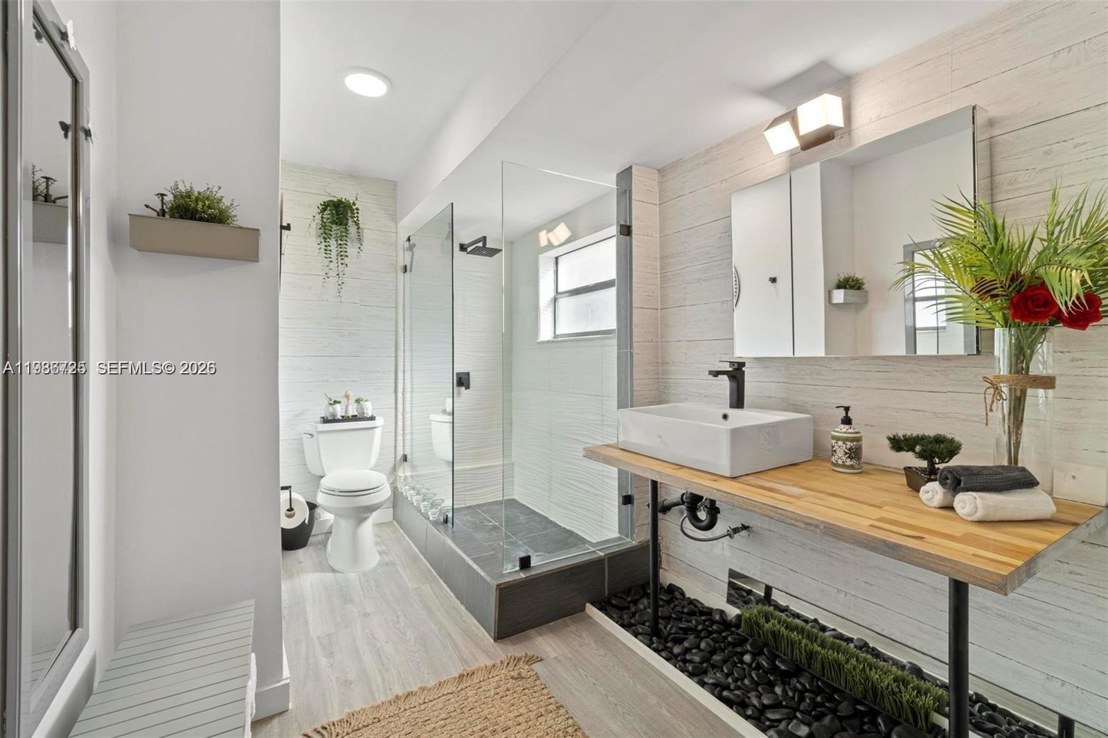 149 Northwest 70th Street, Unit 101C Boca Raton, FL 33487 - Photo 15 of 21 a bathroom with a sink a toilet and shower