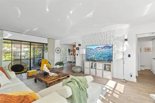 a living room with furniture a flat screen tv and a floor to ceiling window
