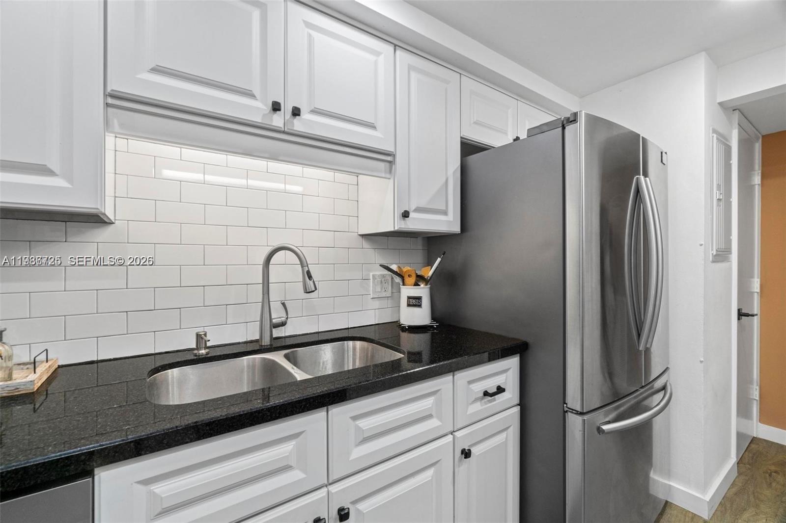 149 Northwest 70th Street, Unit 101C Boca Raton, FL 33487 - Photo 8 of 21 a kitchen with granite countertop a refrigerator and a sink