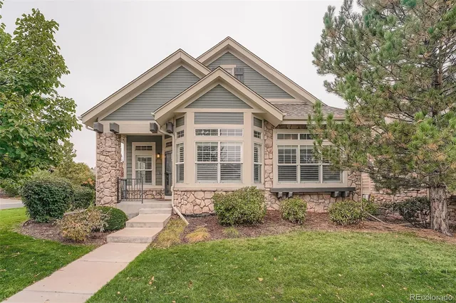 a front view of a house with a yard and potted plants