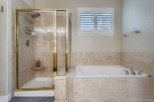 a bathroom with a tub shower and window