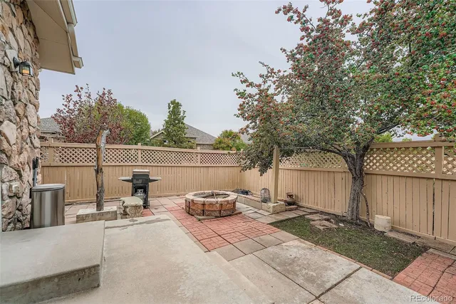 a view of a backyard with sitting area and tree