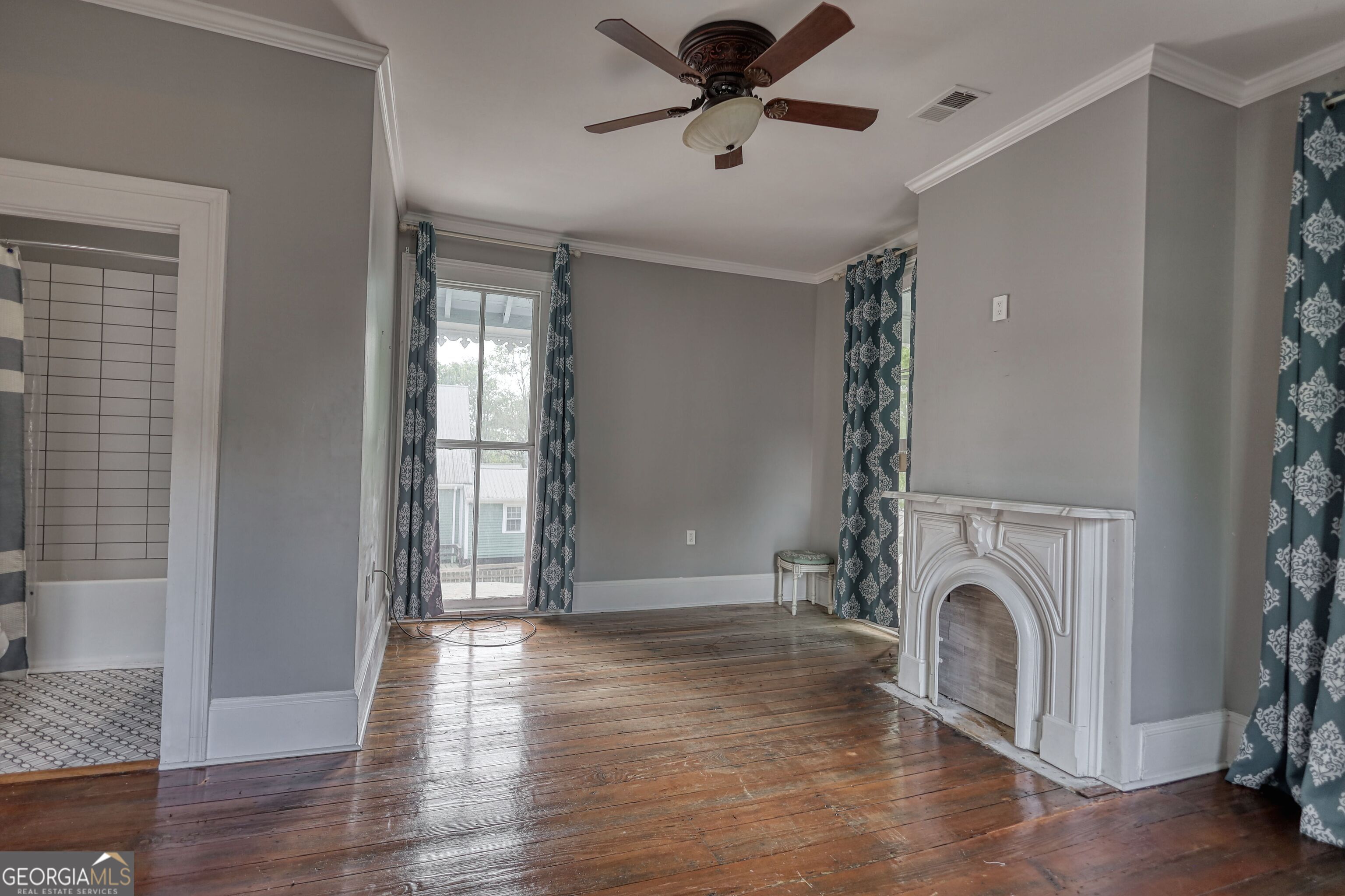 172 North 2nd Street Madison, GA 30650 - Photo 59 of 69 a view of a livingroom with a fireplace a ceiling fan and wooden floor