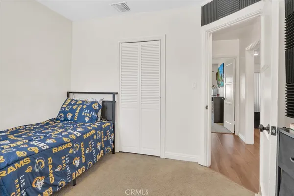 a bedroom with a bed and a painting on the wall